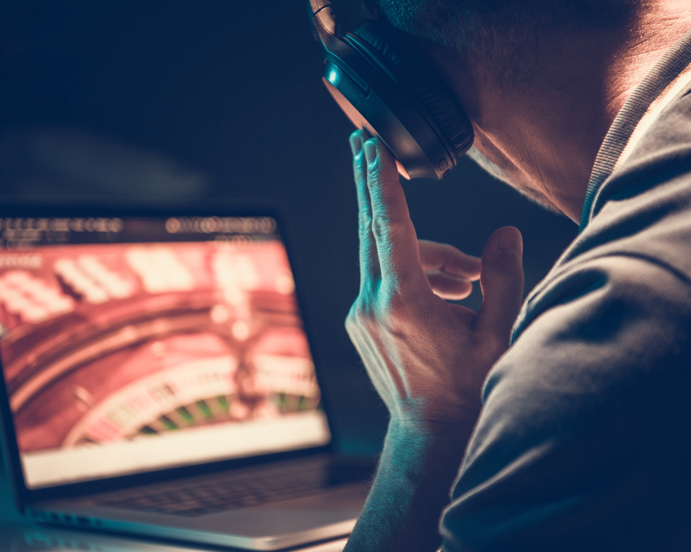 Someone with headphones looking at a laptop