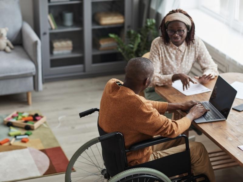 A man in a wheelchair using a laptop